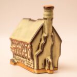 Beige keramische spaarpot in de vorm van een Jacobean huis