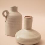 Twee witte keramische Mobach vaasjes, een met handvat en een met tuit.