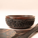 Set van vier houten schalen met diersnijwerk en houten slabestek met olifanten