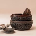 Set van vier houten schalen met diersnijwerk en houten slabestek met olifanten