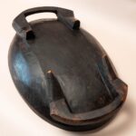 Grote brede houten schaal met twee handvatten aan de voet