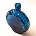 Platte blauwe glazen fles met schelprand