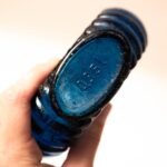 Platte blauwe glazen fles met schelprand