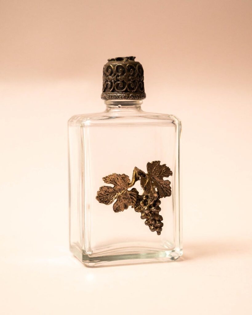 Glazen parfumflesje met zilveren dop en druiventros versiering
