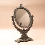 Ronde kaptafelspiegel op standaard met engeltjes decoratie en klein schaaltje