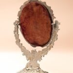 Ronde kaptafelspiegel op standaard met engeltjes decoratie en klein schaaltje